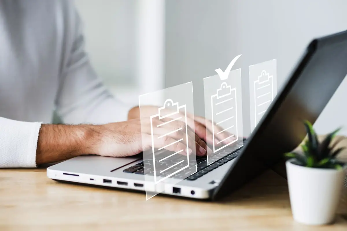Personne en train de remplir un document en ligne depuis son ordinateur