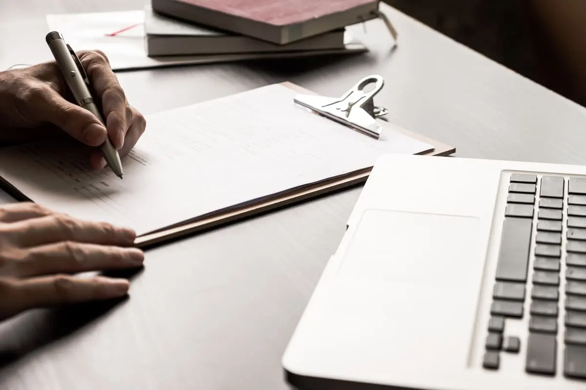 Personne en train de remplir un document papier