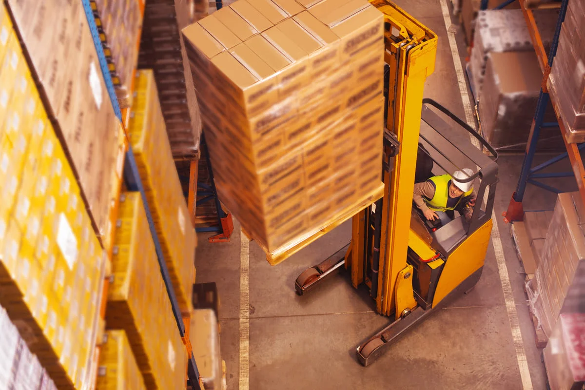 Palette de marchandises en train d'être déplacée via un chariot élévateur